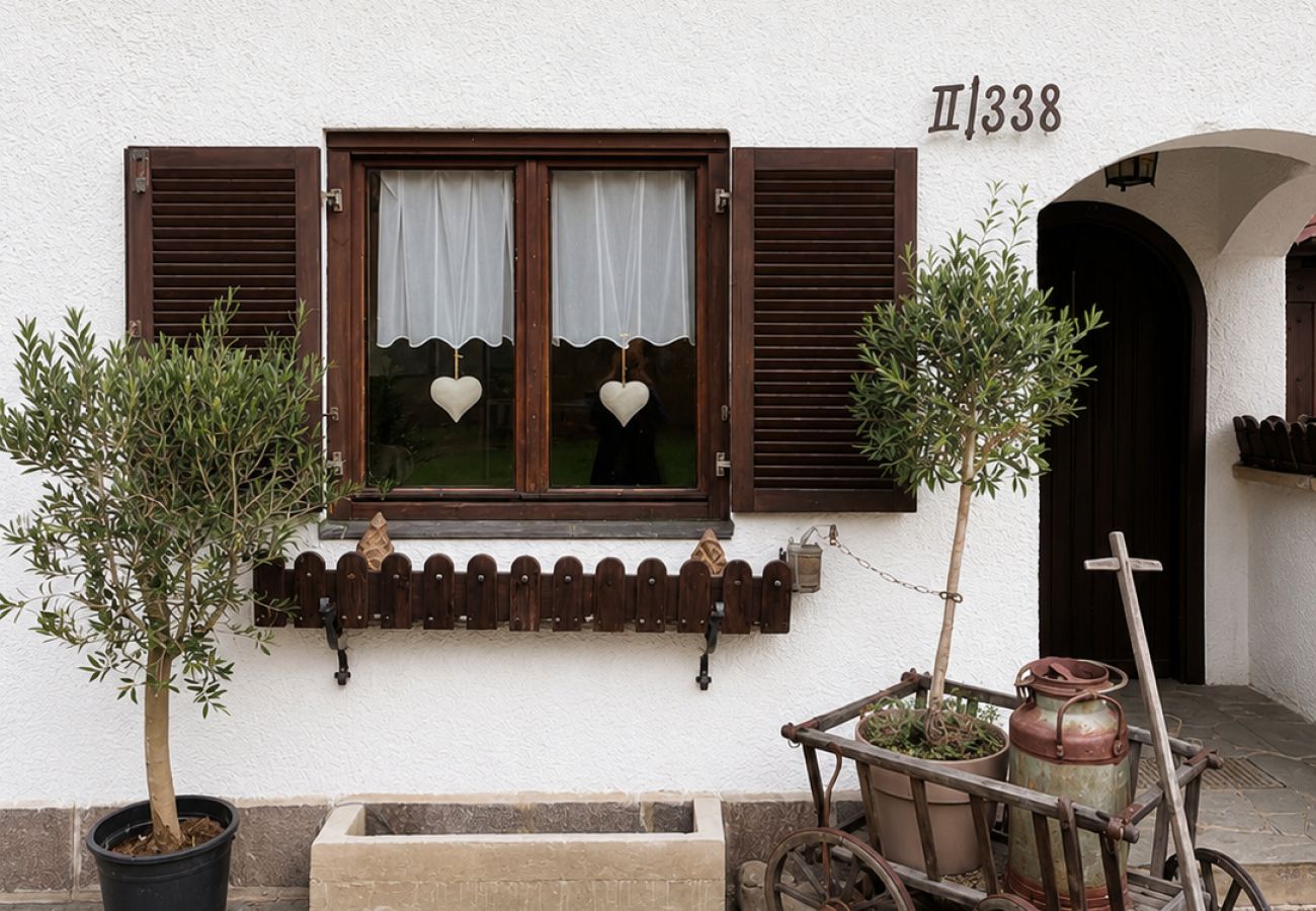 Hauseingang beim Chalet Kirchberg in Tirol mit Fenster, Türbereich, Pflanzen und kleiner Sitzbank